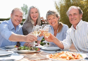 Group of retirees smiling drinking wine