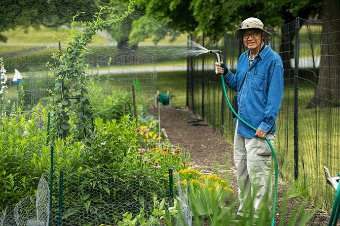 A man watering a community garden