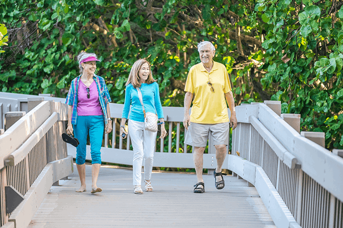 Three people walking together on a bridge