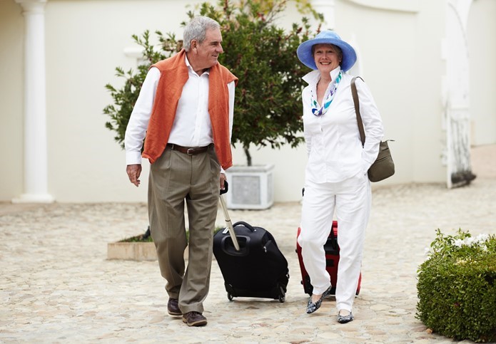 A couple pulling luggage in preparation for a trip